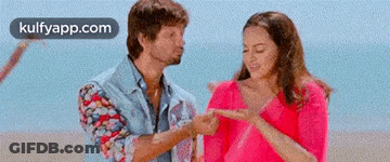 Man Pointing At Woman's Finger On Beach GIF