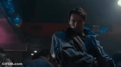 Man Pointing Gun At Another Man In Dark Room GIF