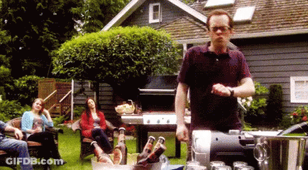 Man Pouring Beer Into Bucket While People Sit On Lawn GIF