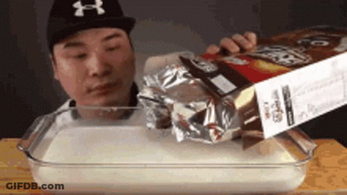 Man Pouring Cereal Into Glass Dish GIF