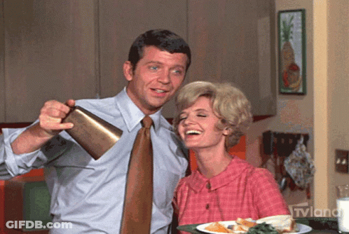 Man Pouring Drink Into Woman's Mouth With TVLand Logo GIF