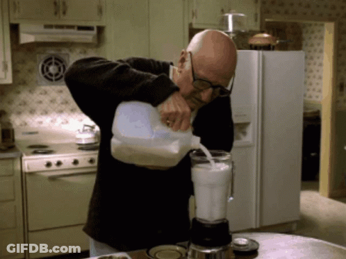 Man Pouring Milk Into Blender In Kitchen GIF