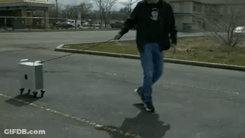 Man Pulling Small Box On A Leash GIF