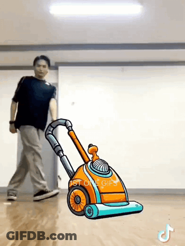 Man Pushing Cartoon Vacuum Cleaner In Dance Studio GIF