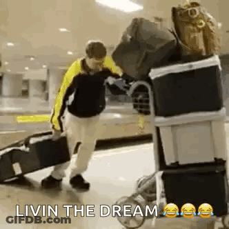 Man Pushing Luggage Cart Saying Livin The Dream GIF