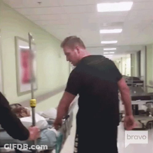 Man Pushing Patient On Stretcher In Hospital Hallway Bravo GIF