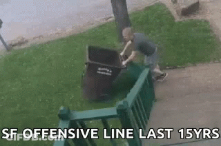 Man Pushing Trash Can Over Green Railing GIF