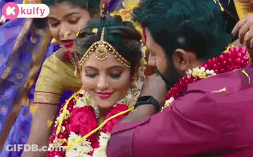 Man Putting Garland On Woman's Neck GIF
