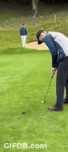 Man Putting Golf Ball While Another Watches GIF