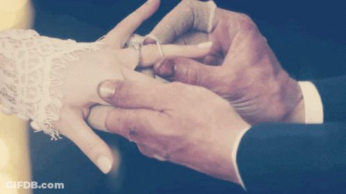 Man Putting Ring On Woman's Finger GIF