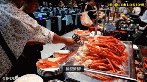 Man Reaching Into Tray Of Crab Legs With Tongs GIF