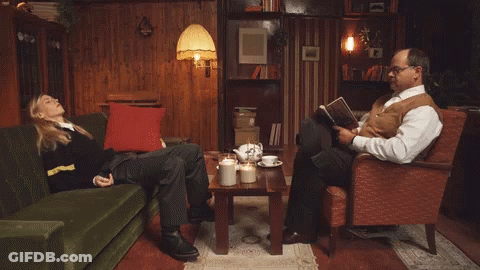 Man Reading Book Beside Woman On Couch GIF