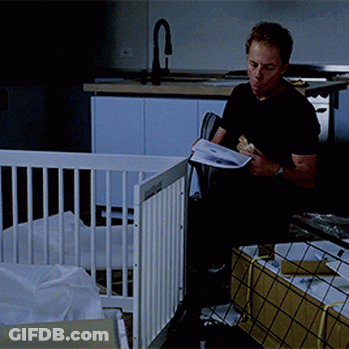 Man Reading Book In Front Of Baby Crib GIF