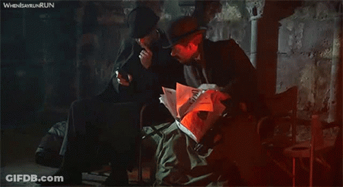 Man Reading Newspaper And Man On Phone GIF