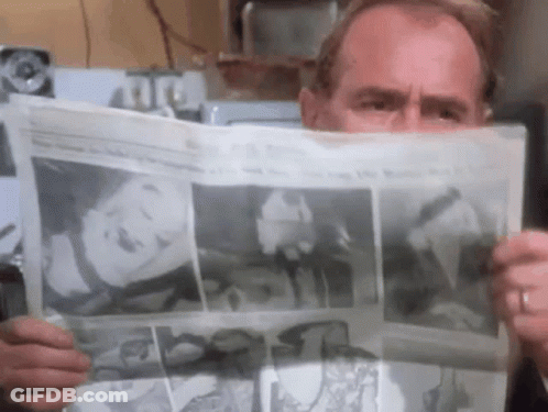 Man Reading Newspaper With Woman On Front GIF