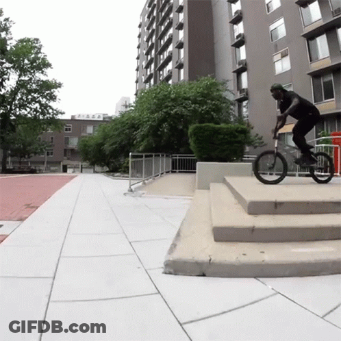 Man Riding Bike Down Stairs Past Building Saying A GIF
