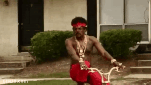 Man Riding Bike In Front Of House GIF