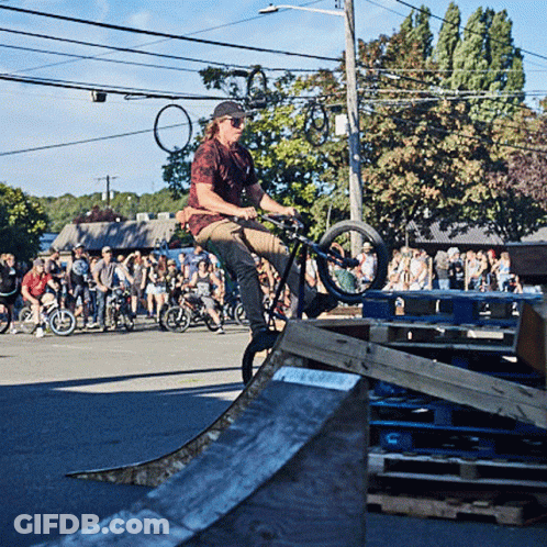 Man Riding Bike On Ramp As Crowd Watches GIF