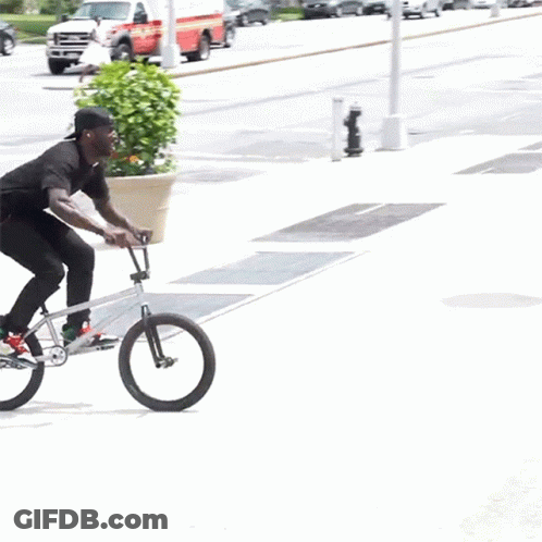Man Riding Bike On Sidewalk Next To Staircase GIF