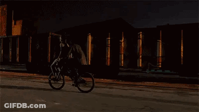 Man Riding Bike On Street At Night GIF
