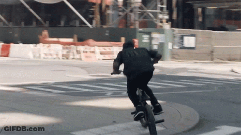 Man Riding Bike Past One Way Sign GIF