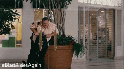Man Riding Exercise Bike In Front Of Bath & Body Works GIF