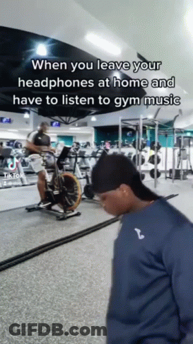 Man Riding Exercise Bike With Headphones GIF