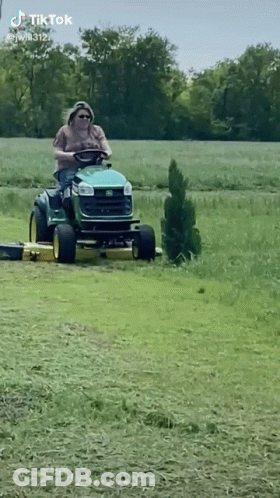Man Riding Lawn Mower In Field GIF