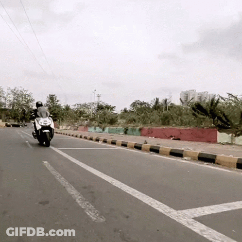 Man Riding Motorcycle Down Road GIF