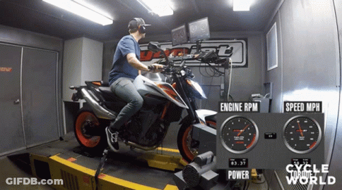 Man Riding Motorcycle In Room With Cycle World Sign GIF