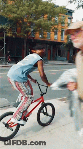 Man Riding Red Bike Down Street GIF