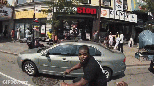 Man Riding Scooter In Front Of Free Stop Store GIF