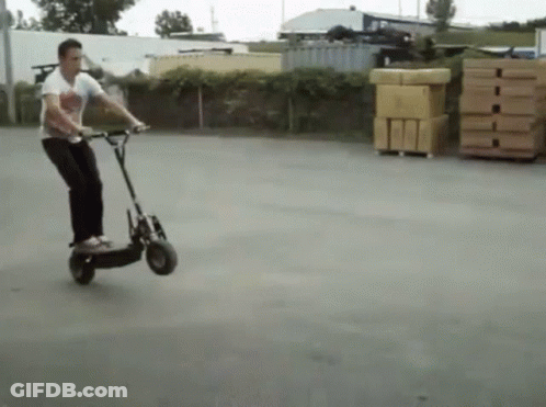 Man Riding Scooter In Parking Lot GIF