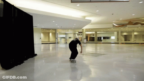 Man Riding Skateboard In Large Room GIF