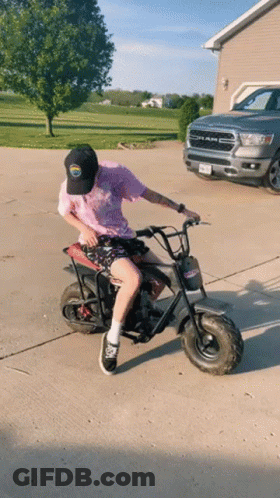 Man Riding Small Motorcycle Beside Ram Truck GIF