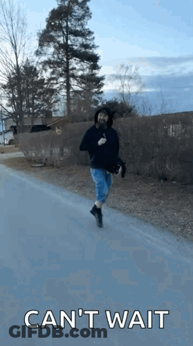 Man Running Down Road With Cant Wait Behind Him GIF