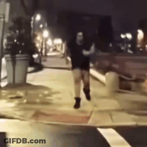 Man Running Down Sidewalk At Night GIF