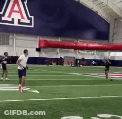 Man Running On Football Field Past Sign Saying A GIF