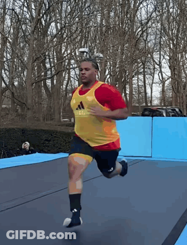 Man Running On Trampoline In Red And Yellow Adidas Vest GIF