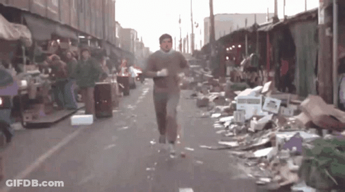 Man Running Past Pile Of Cardboard Boxes GIF