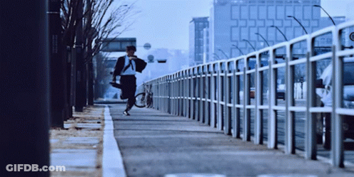 Man Running With Bicycle On Sidewalk GIF
