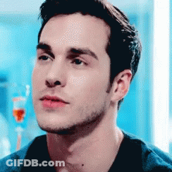 Man's Face Close Up In Front Of Blue Wall GIF