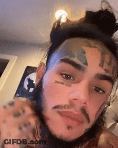 Man's Face With Bun And Tattoos GIF