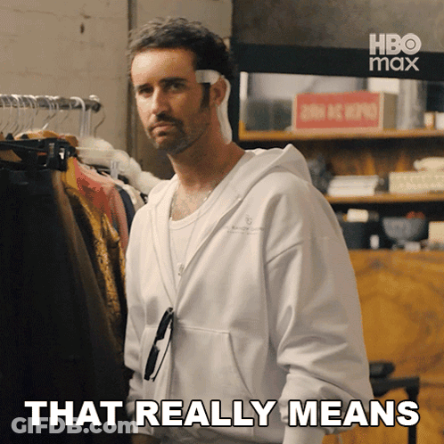 Man Saying That Really Means In Front Of Clothes Rack GIF