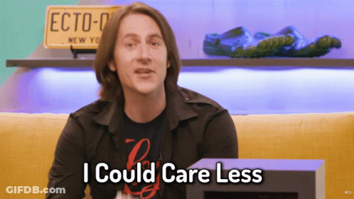 Man Says I Could Care Less In Front Of Yellow Couch GIF