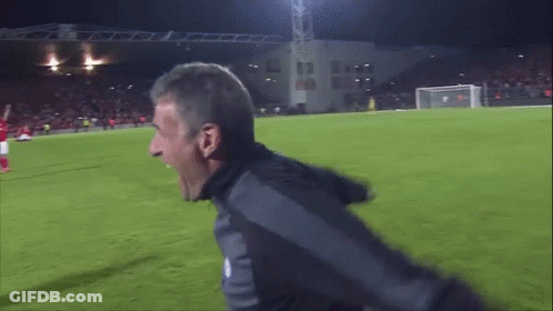 Man Screaming On Soccer Field In Front Of Building Saying AA GIF