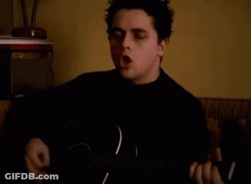 Man Singing And Playing Guitar In Dark Room GIF