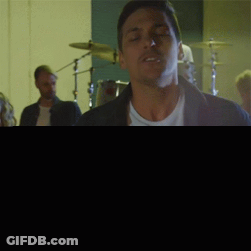 Man Singing In Front Of Drum Set GIF