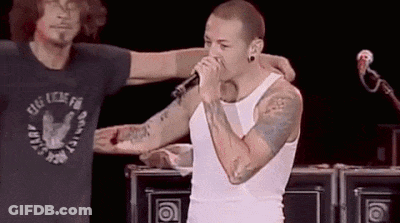 Man Singing Into Mic With Arm Around GIF