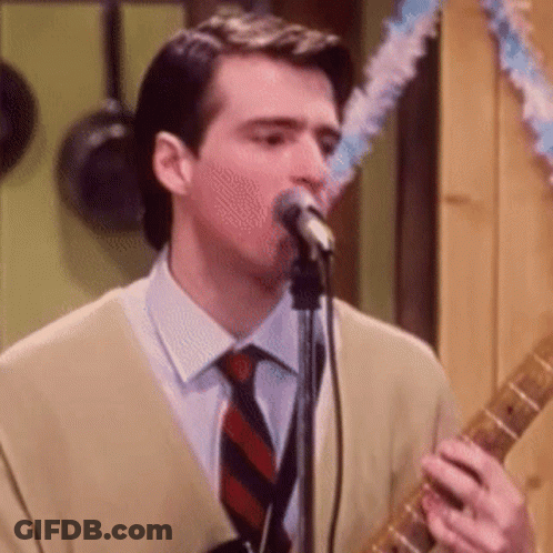 Man Singing Into Microphone And Playing Guitar GIF